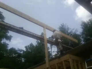 Carpenter setting a ridge beam over a new addition frame — Ice Dam Removal by Roofing Brothers in Mount Marion