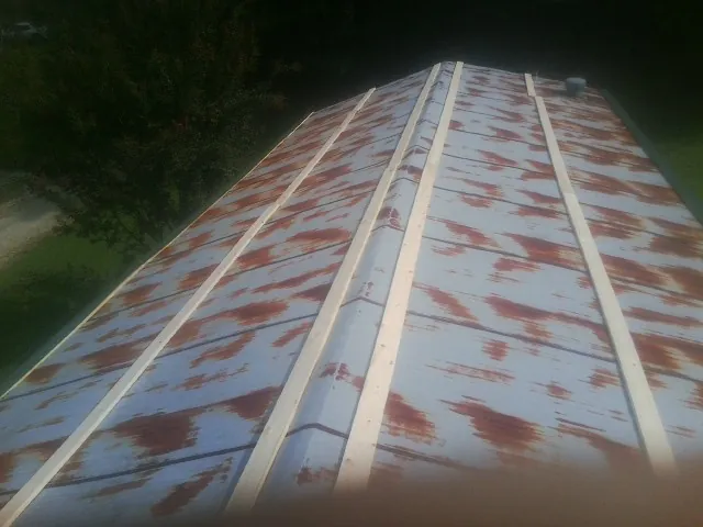 Rusted metal roof panels with new wood purlins before replacement — Storm Damage Roof Repair in Mount Marion by Roofing Brothers