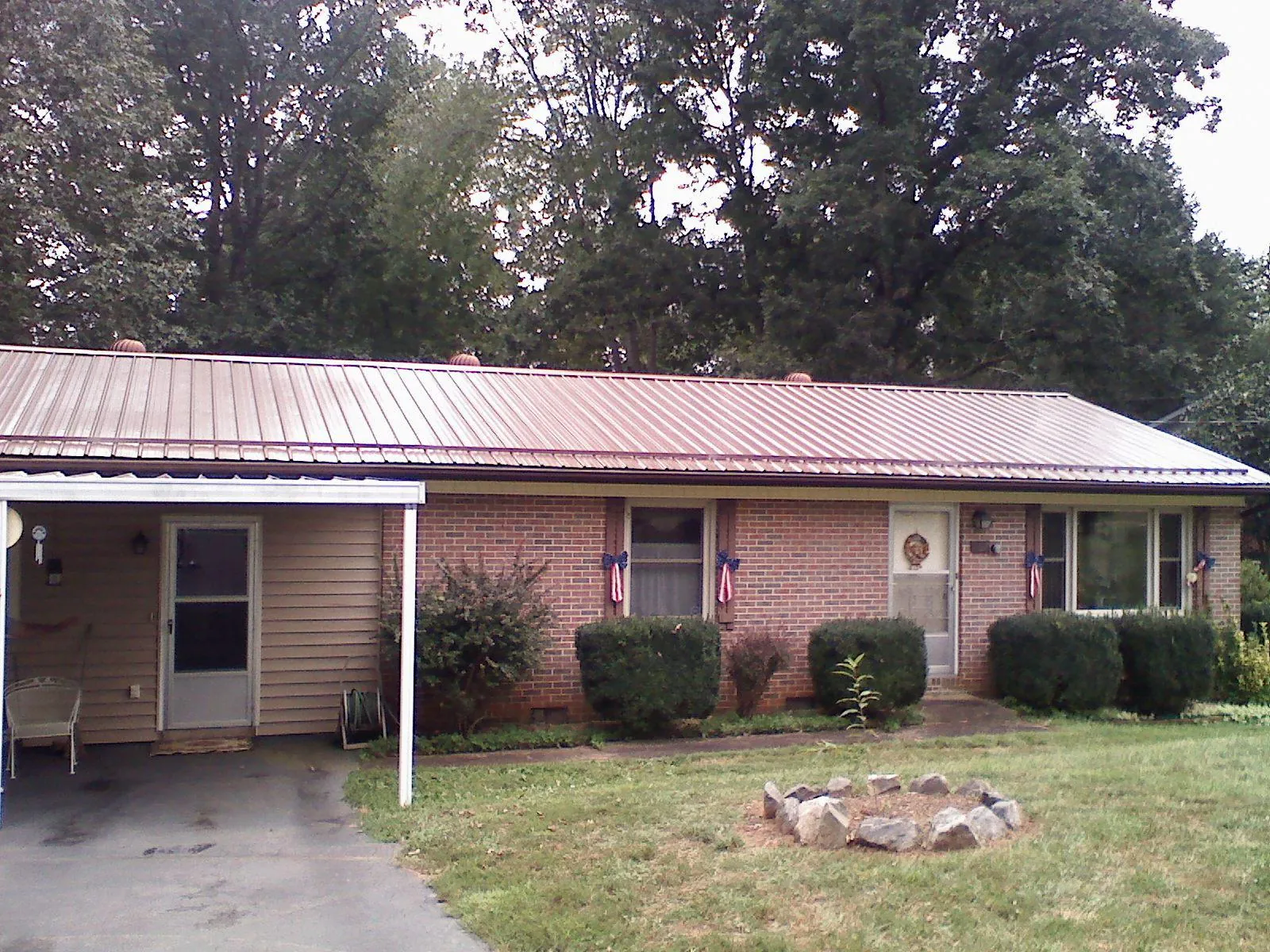 Bronze metal roof and carport on a brick ranch home — Roof Repair work by our crew in Mount Marion